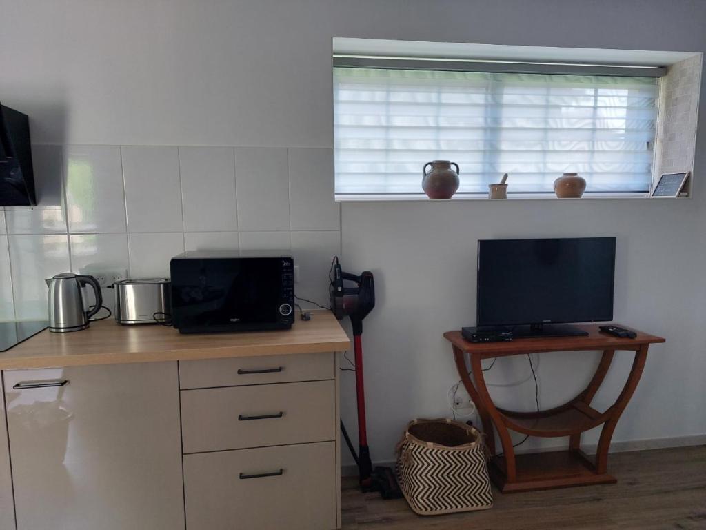 a kitchen with a desk with a computer and a television at Studio2 Fontaine de L'amour in Sarlat-la-Canéda