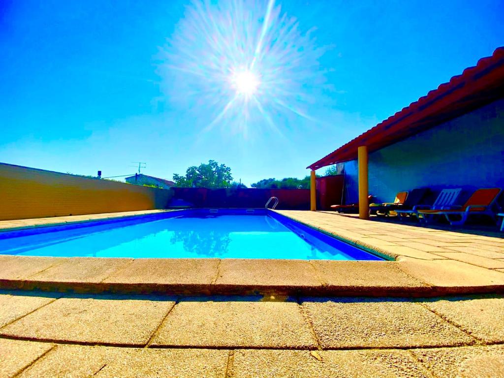 a swimming pool on a patio next to a house at 1955 Guest House in Cebolais de Cima