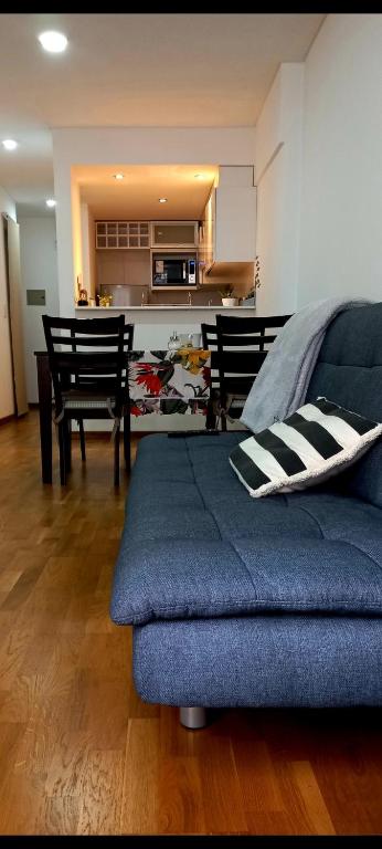 sala de estar con sofá azul y cocina en '' Siempre Cerca '' aparcamiento gratuito en Rosario