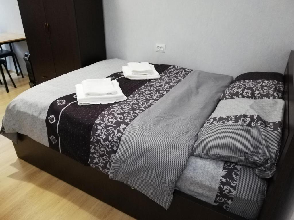 uma cama com duas toalhas em cima em Siemens House em Tbilisi