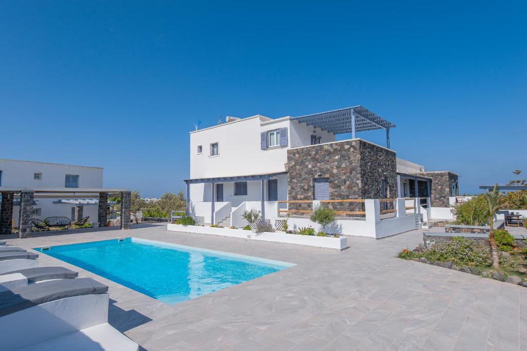 een villa met een zwembad voor een huis bij Golden Sunrise Suites in Kamari