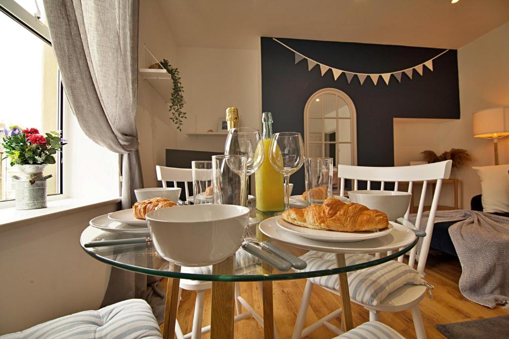 un tavolo con piatti di croissant e bicchieri da vino di 'Bridgewater' at stayBOOM a Morecambe