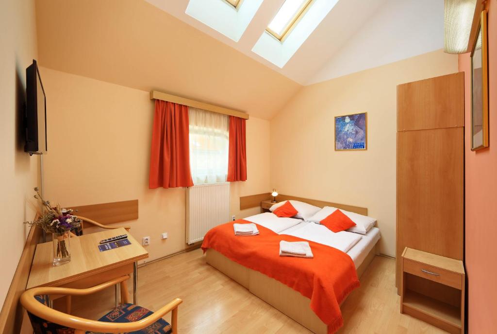 a bedroom with a bed, desk and a lamp at Residence Tabor in Prague