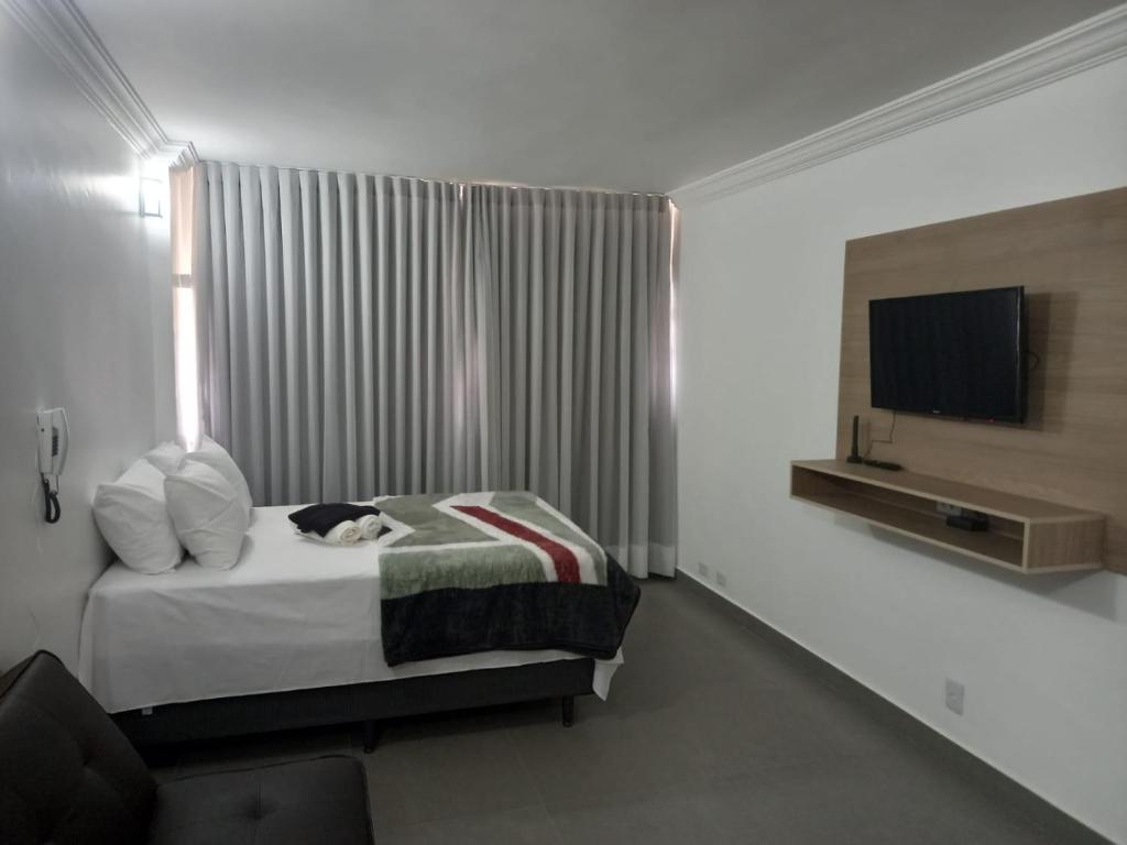 una camera da letto con un gatto sdraiato su un letto di Apartamento 1011 a Goiânia
