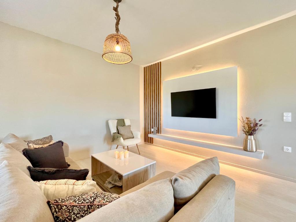 uma sala de estar com um sofá e uma televisão em Elysian Studios em Roda
