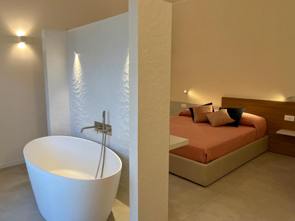 B&B LE MAGNOLIE في تيرمولي: حمام به سرير وحوض استحمام