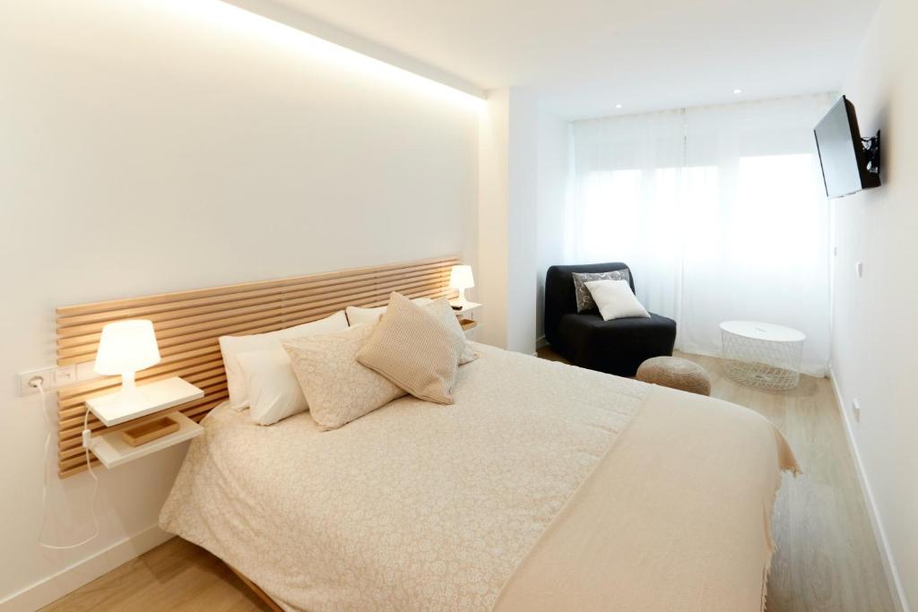 a bedroom with a large bed and a chair at Precioso Loft zona Santiago Bernabéu Madrid in Madrid