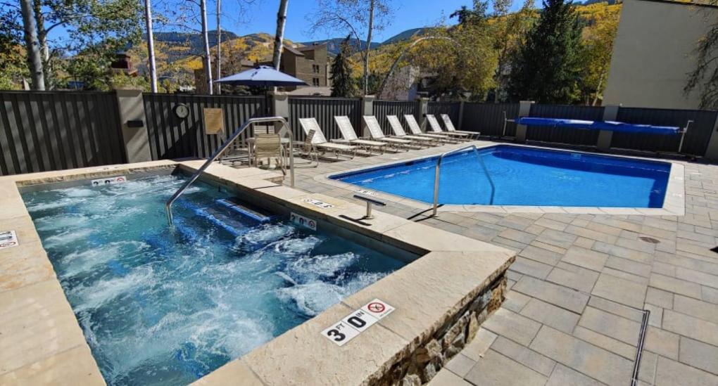 una piscina en un patio con sillas alrededor en Best location in the heart of lions head, Ski lockers, jacuzzi and pool, en Vail