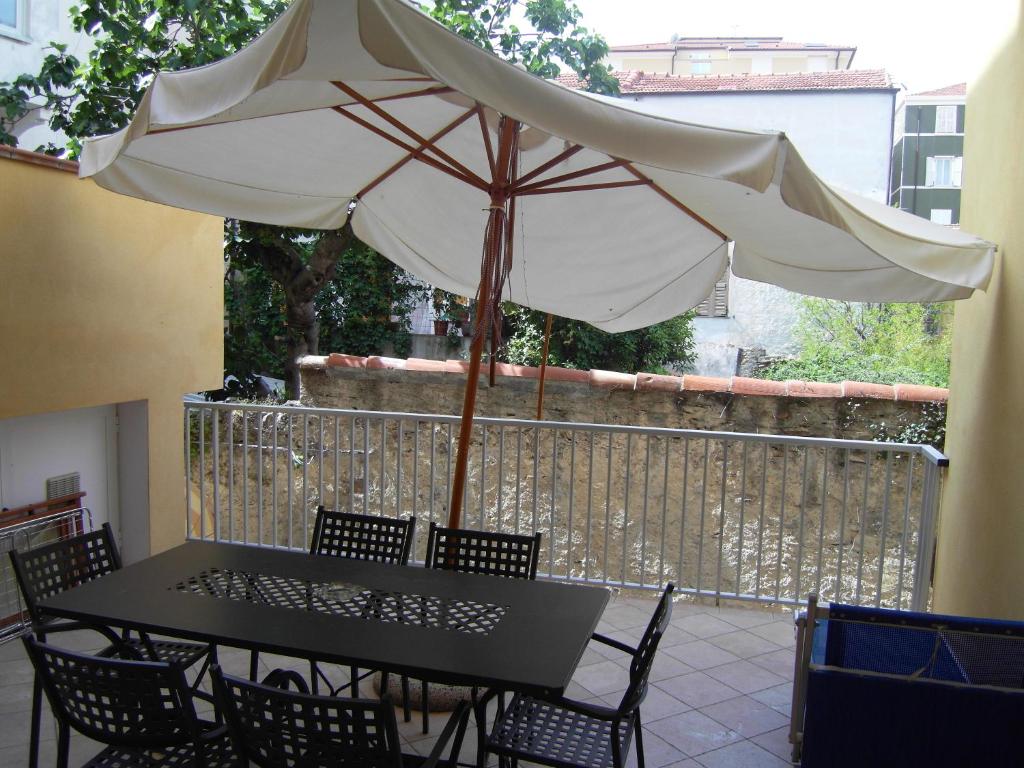 een zwarte tafel met een witte parasol op een patio bij Residence Panama in Alassio