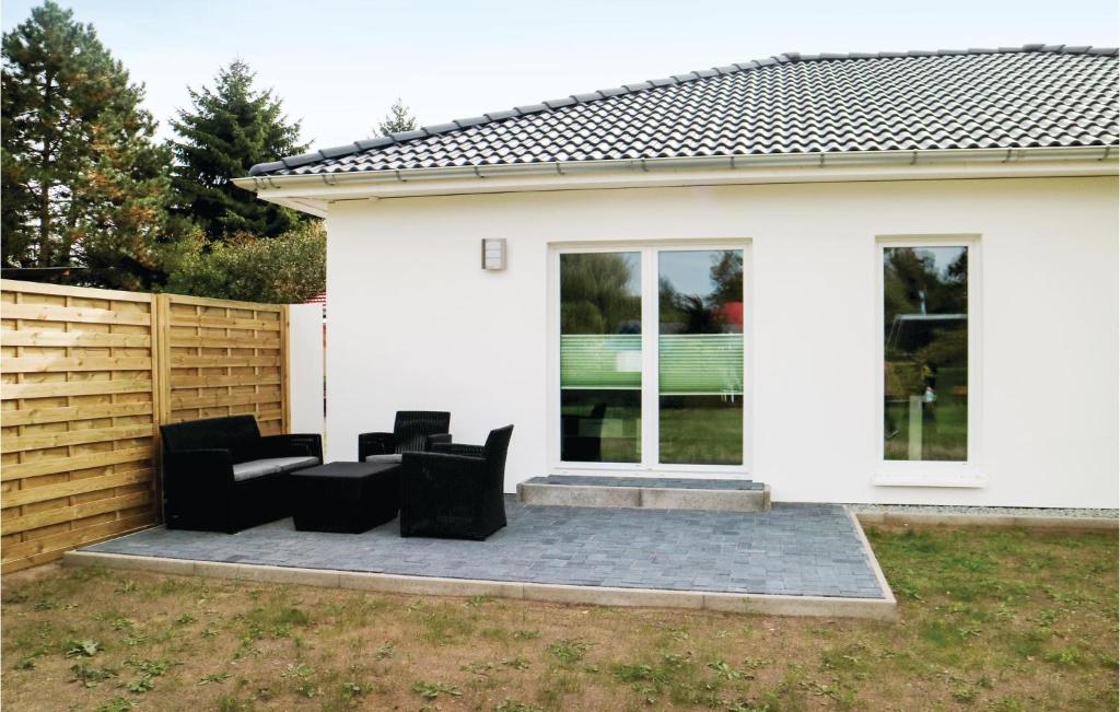 a patio with black chairs in front of a white house at 2 Bedroom Stunning Home In Rostock-rvershagen in Rövershagen