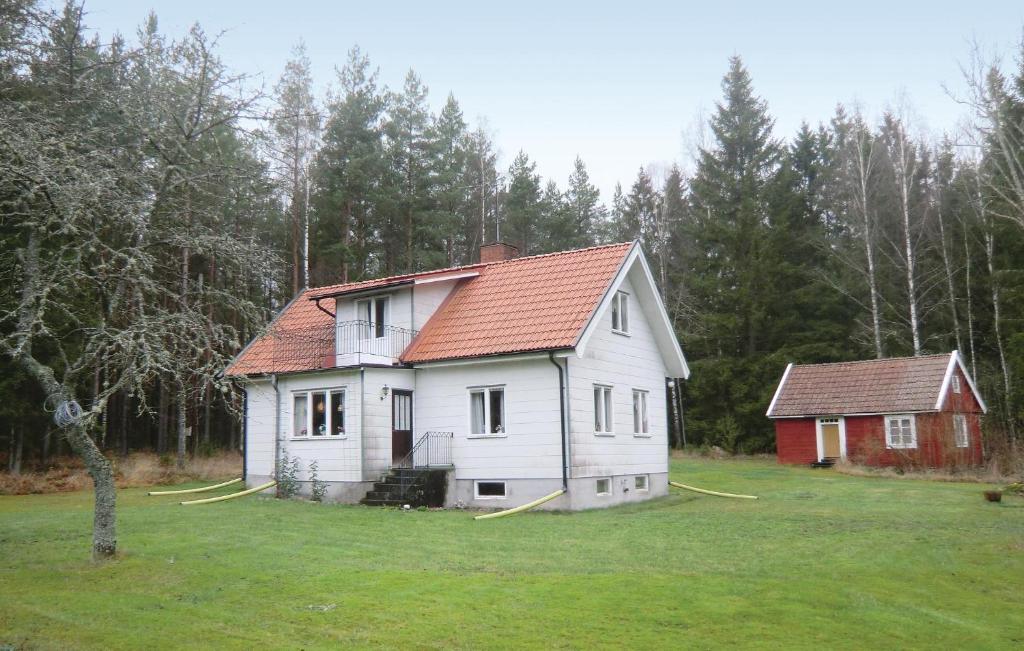 a white house with a red roof in a field at Lovely Home In Mnsters With Kitchen in Mönsterås
