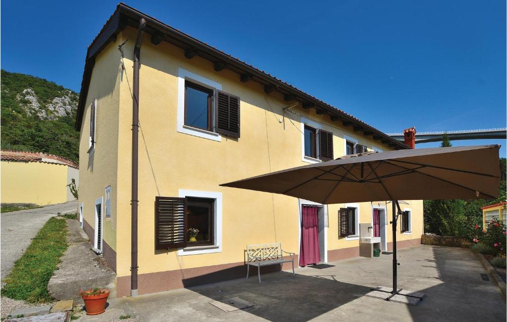 a yellow building with an umbrella in front of it at 4 Bedroom Beautiful Home In Crni Kal in Črni Kal