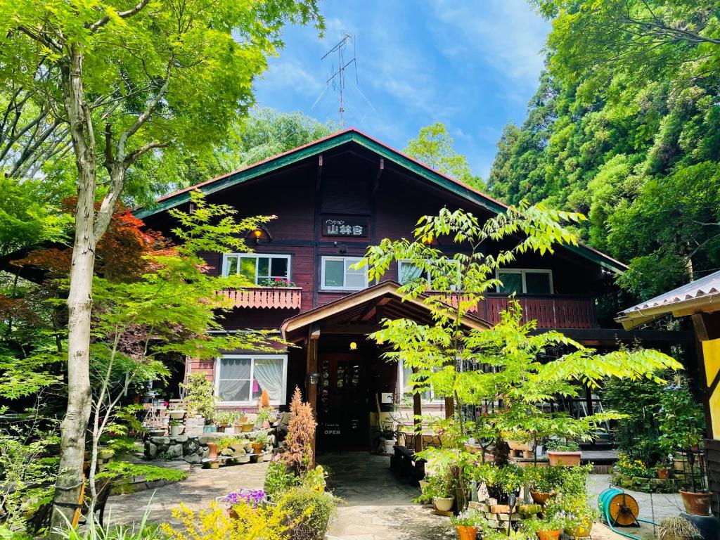 un gran edificio con un montón de plantas delante de él en Sanrinsha, en Takamori