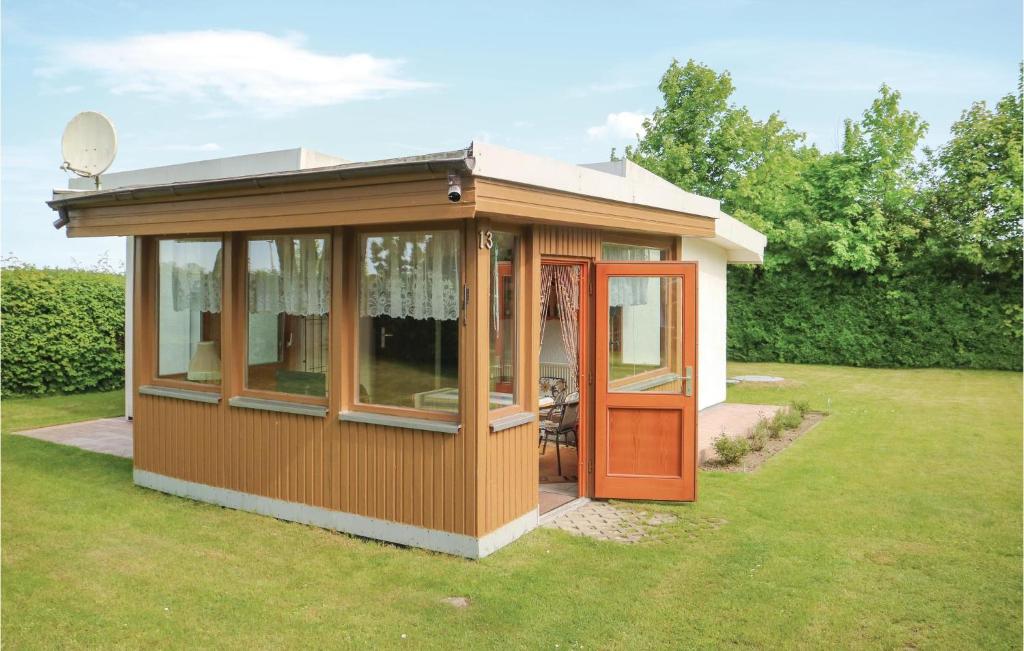 ein kleines Haus mit einer orangefarbenen Tür im Hof in der Unterkunft Ferienhaus Zur Ostsee P in Wichmannsdorf