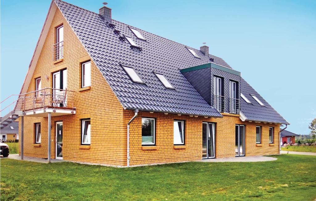 une grande maison en briques avec un toit noir dans l'établissement Golfpark Strelasund, à Kaschow