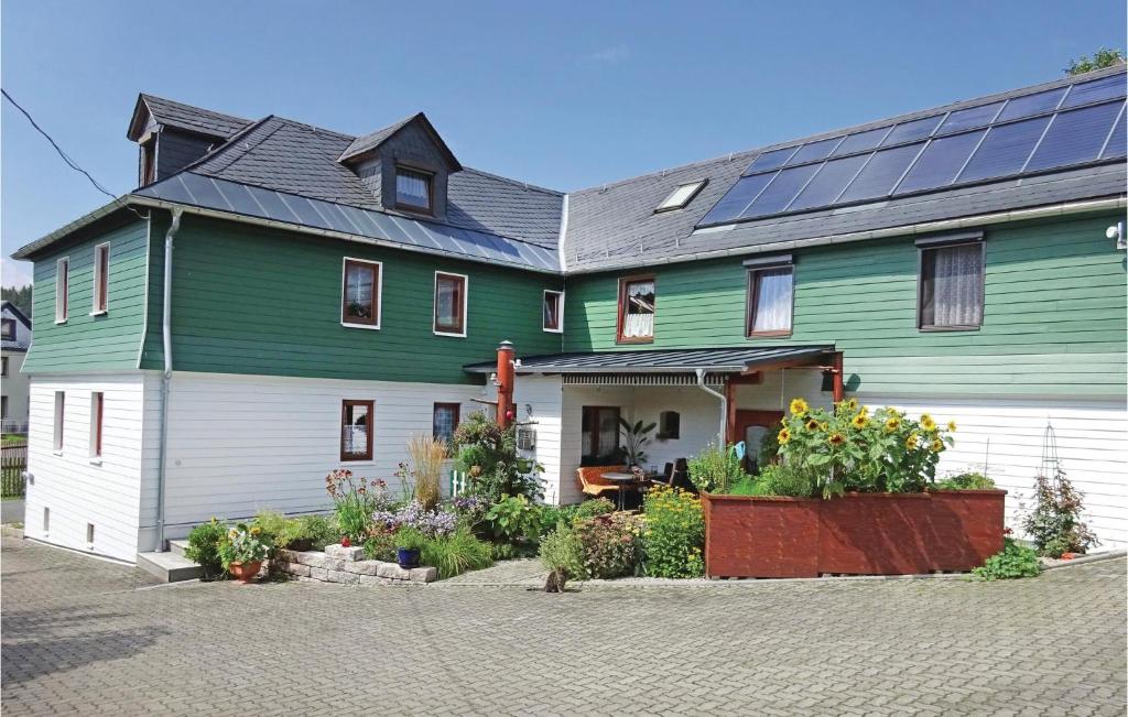 a green and white house with solar panels on it at Beautiful Apartment In Remptendorf With Kitchen in Gleima