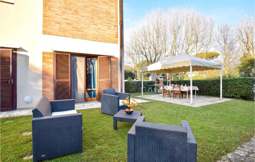 un patio con 2 sillas y una sombrilla en Awesome Apartment In Lido Di Camaiore With Wifi, en Lido di Camaiore