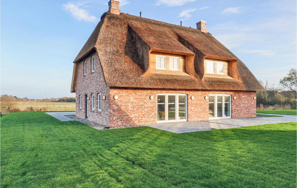 une maison ancienne avec un toit de chaume sur une pelouse dans l'établissement 3 Bedroom Beautiful Home In Dagebll, à Dagebüll