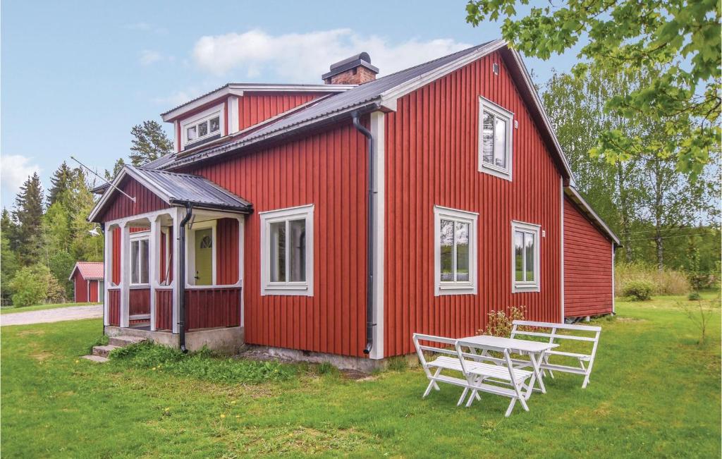 une maison rouge avec une table devant elle dans l'établissement 2 Bedroom Nice Home In motfors, à Åmotsfors