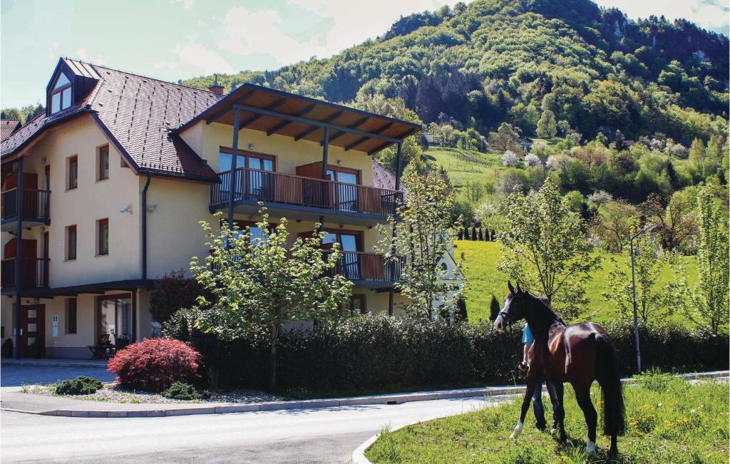 a horse walking in front of a house at Nice Apartment In Lasko With House A Mountain View in Laško