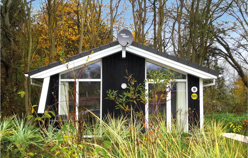 ein kleines schwarzweißes Haus im Gras in der Unterkunft Pulverhorn 9 - Dorf 4 in Travemünde