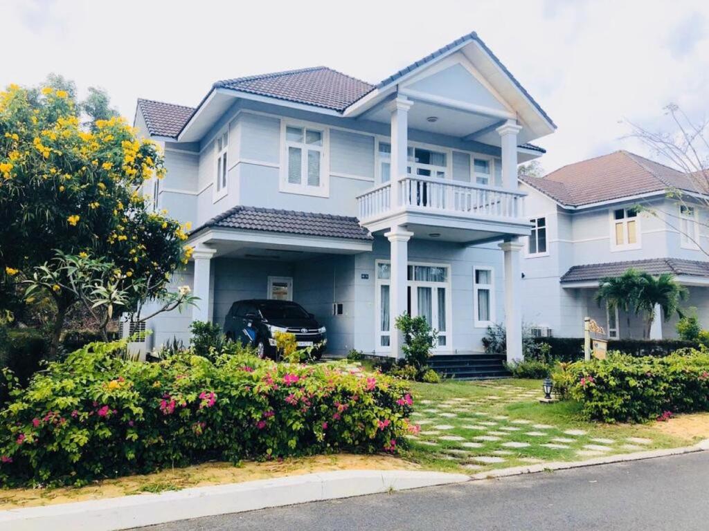 een wit huis met bloemen ervoor bij Bougain Villa - Sealinks Mũi Né - chuỗi biệt thự liền kề in Phan Thiet