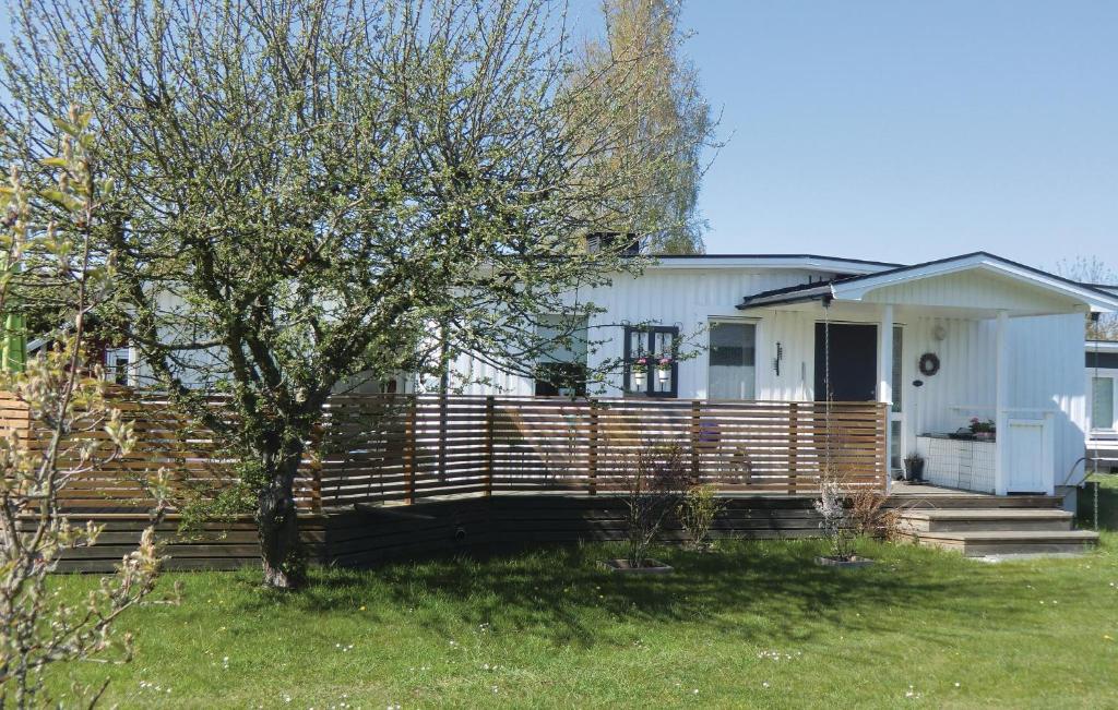 シーピンスリーにあるCozy Home In Kpingsvik With Kitchenの庭の木塀のある家