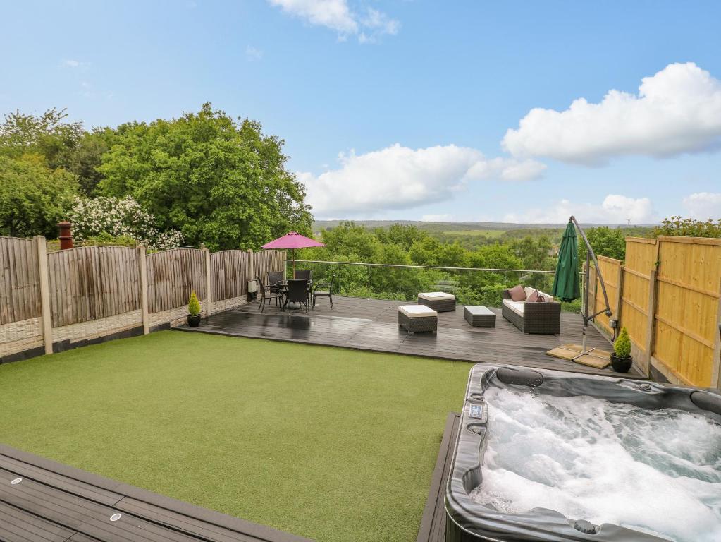 a backyard with a jacuzzi tub and a patio at Hollinwell View in Nottingham