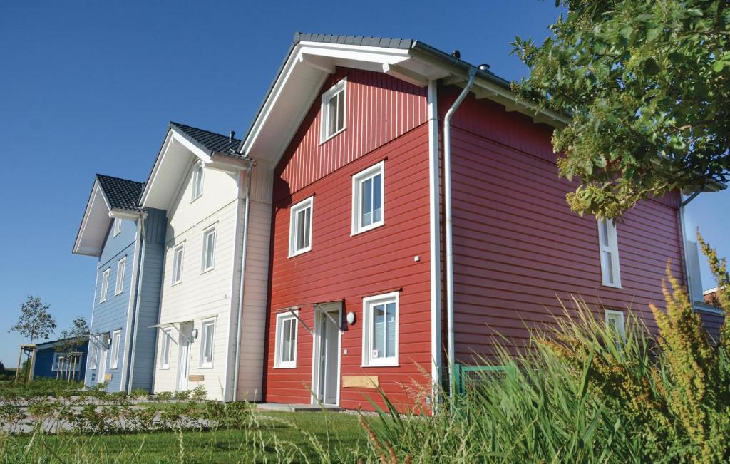 ein rotes Haus mit zwei weißen Häusern in der Unterkunft Ferienhaus Dageb�ll 19 in Dagebüll