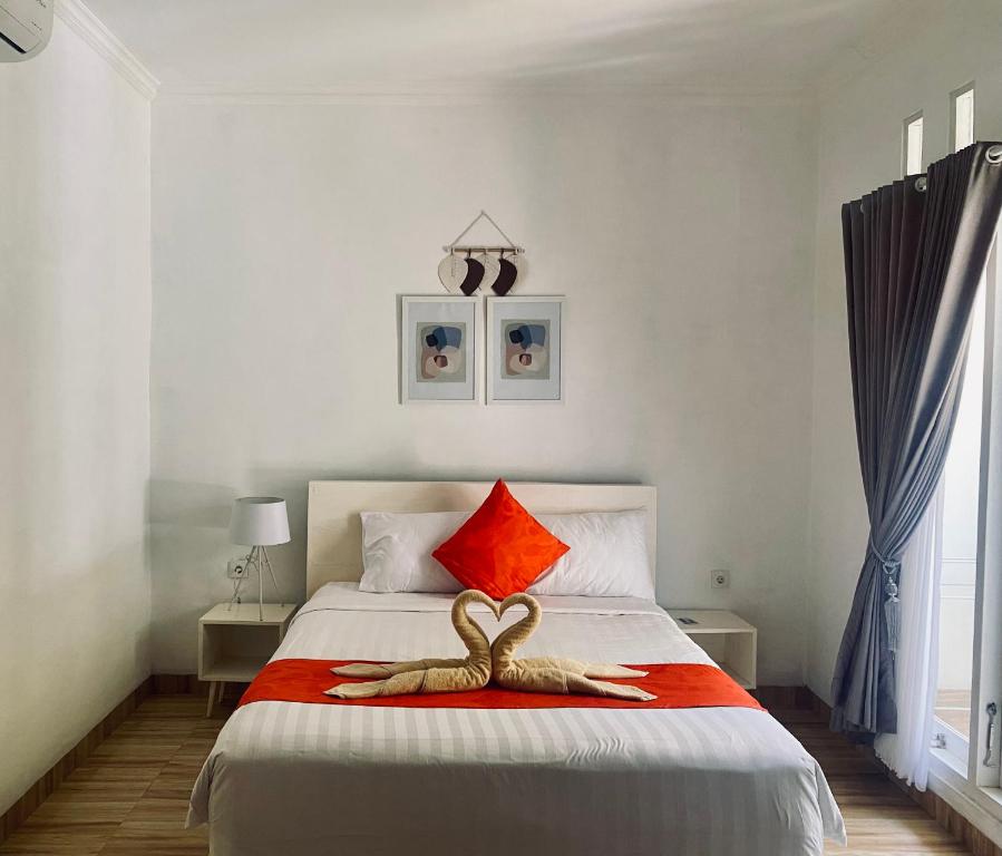 Un dormitorio con una cama con dos cisnes. en Umah Putih, en Nusa Penida
