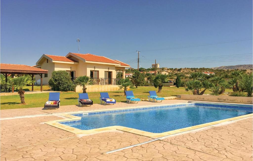 uma piscina com espreguiçadeiras e uma casa em Gorgeous Home In Maroni-larnaca With Outdoor Swimming Pool em Pervolia