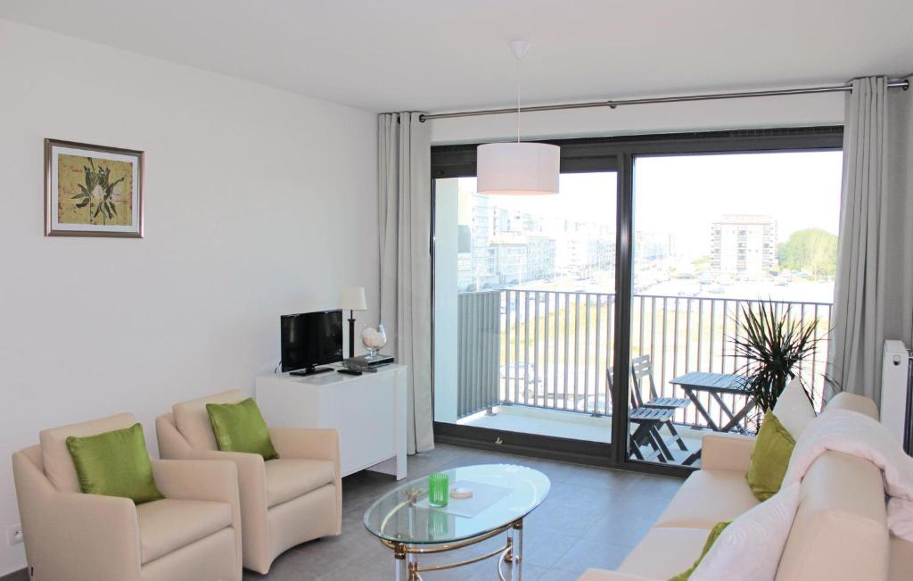 un soggiorno con divano e sedie e un balcone di Residentie Crystal Ref 93 a Ostenda