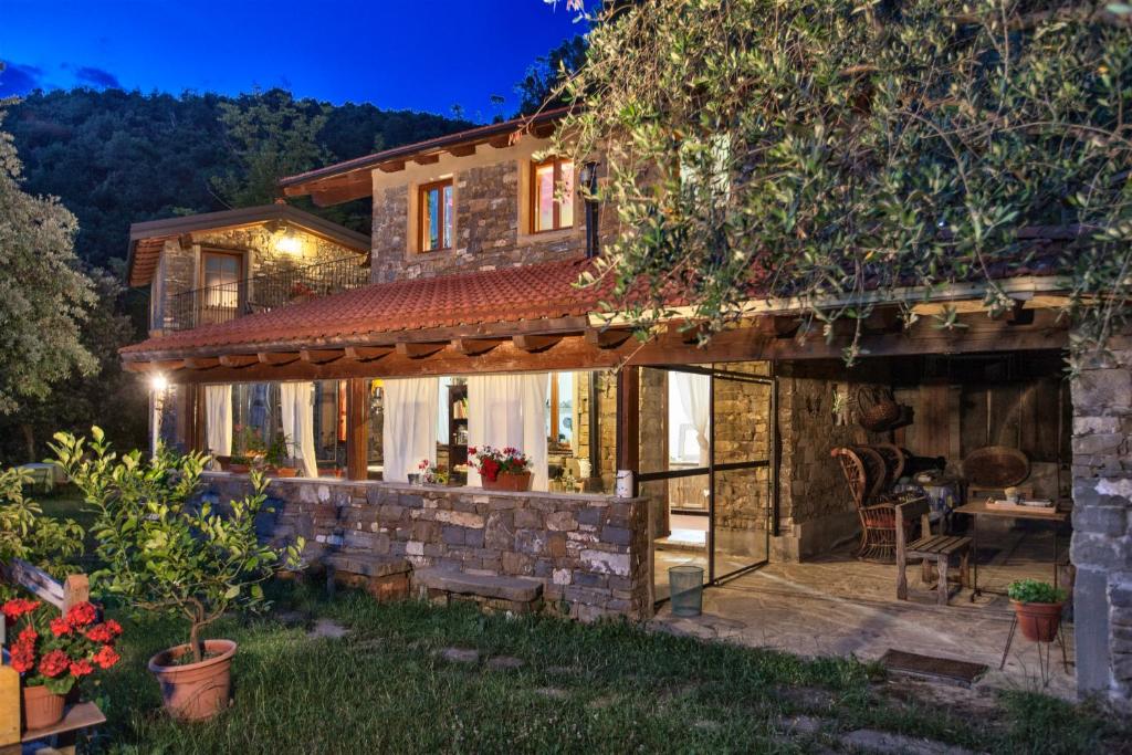 a house with a stone wall and a patio at Agriturismo Terre Del Mistero in Apricale