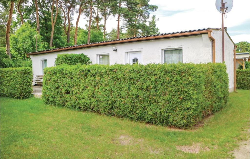 a hedge in front of a white house at One-Bedroom Holiday Home In Bellin in Bellin