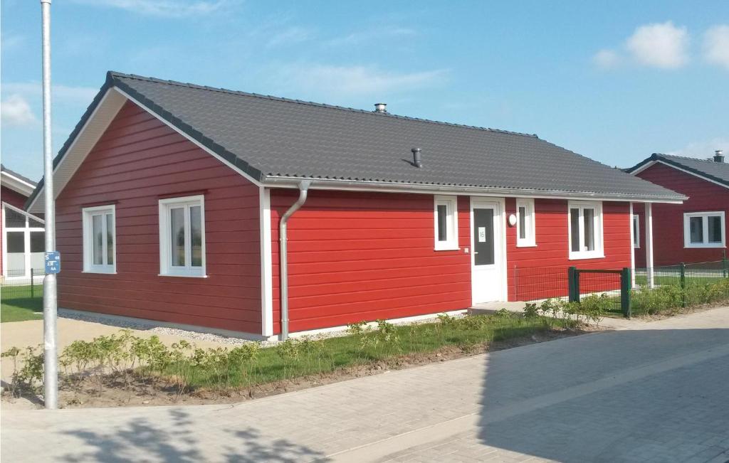 ein rotes Haus mit schwarzem Dach in der Unterkunft Amazing Home In Dagebll With 2 Bedrooms, Sauna And Wifi in Dagebüll