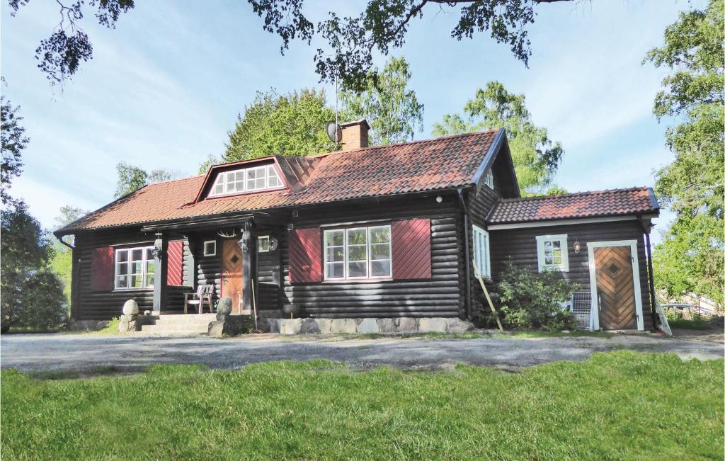 una vieja casa negra con techo rojo en Stunning Home In Kvicksund With House Sea View en Kvicksund