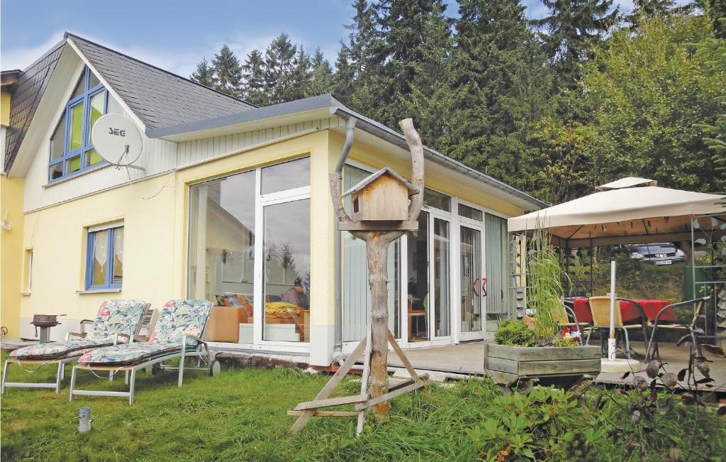 ein kleines gelbes Haus mit einem Vogelhaus im Hof in der Unterkunft Ferienhaus Hauptstrasse Y in Weitersglashütte