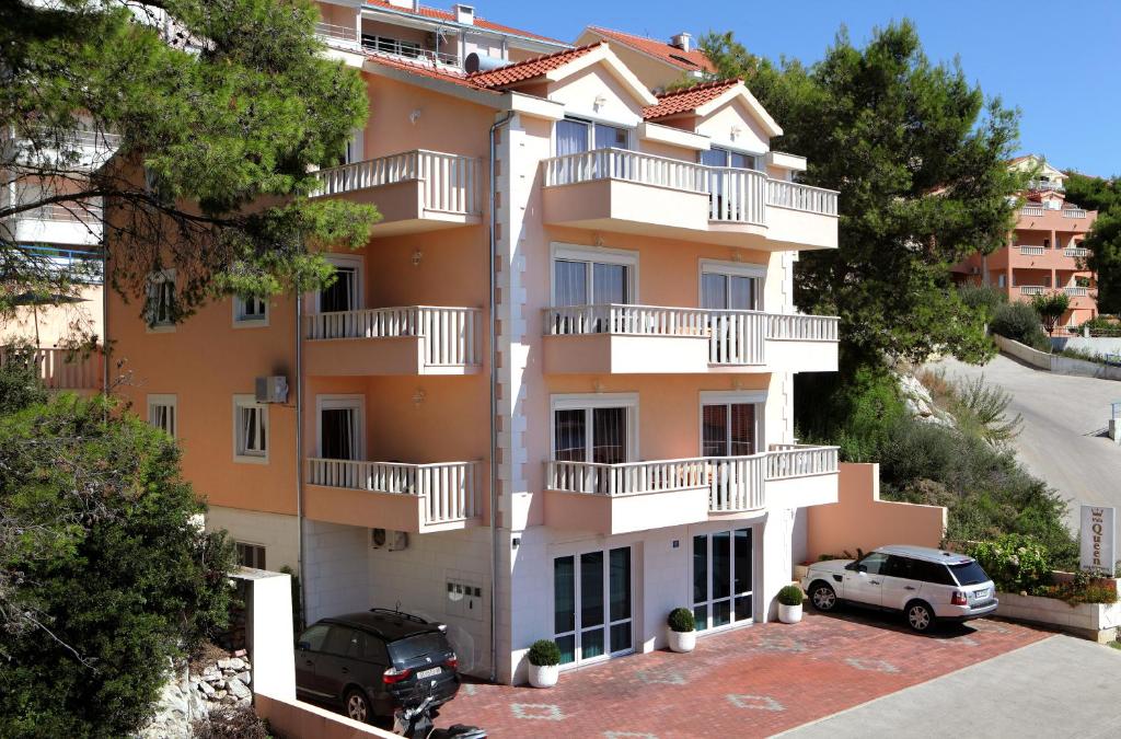 un condominio con auto parcheggiate in un parcheggio di Villa Queen a Trogir