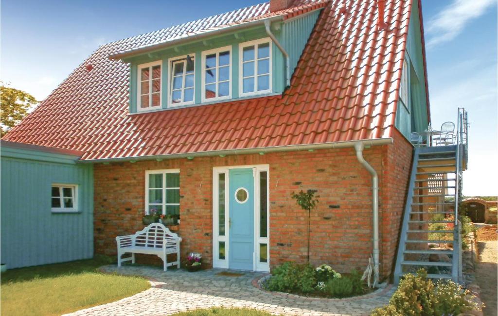 a red brick house with a blue door at Haus Nixe in Börgerende-Rethwisch