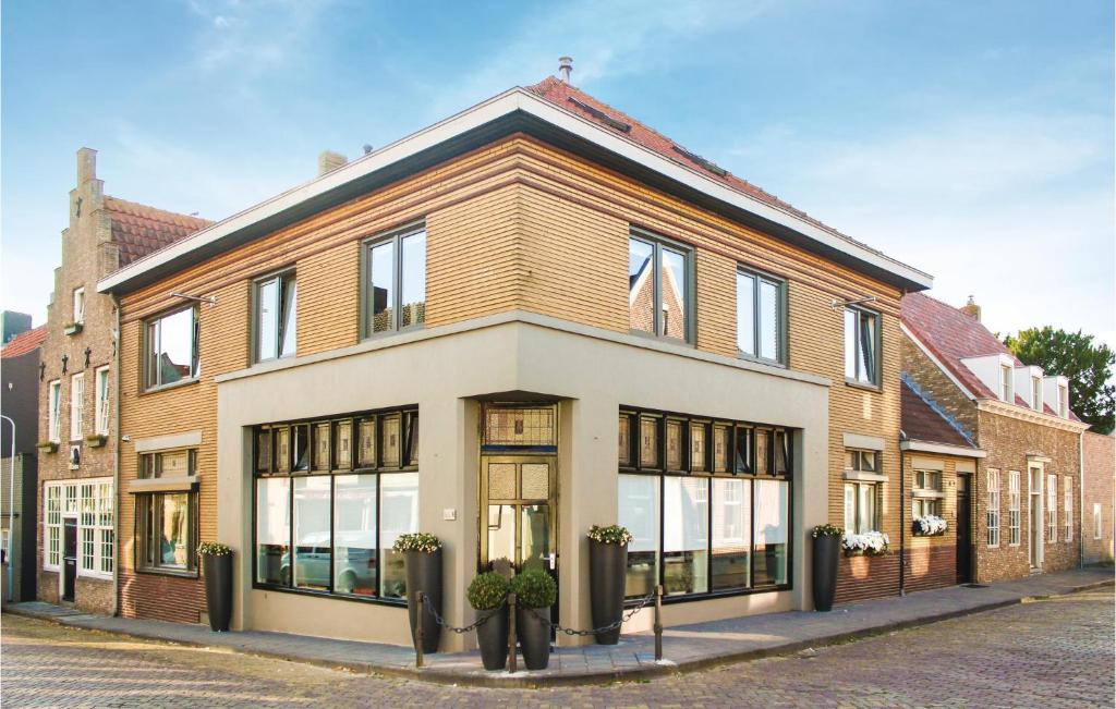 un gran edificio de ladrillo con ventanas en una calle en Amazing Home In Ijzendijke With 3 Bedrooms And Wifi, en IJzendijke