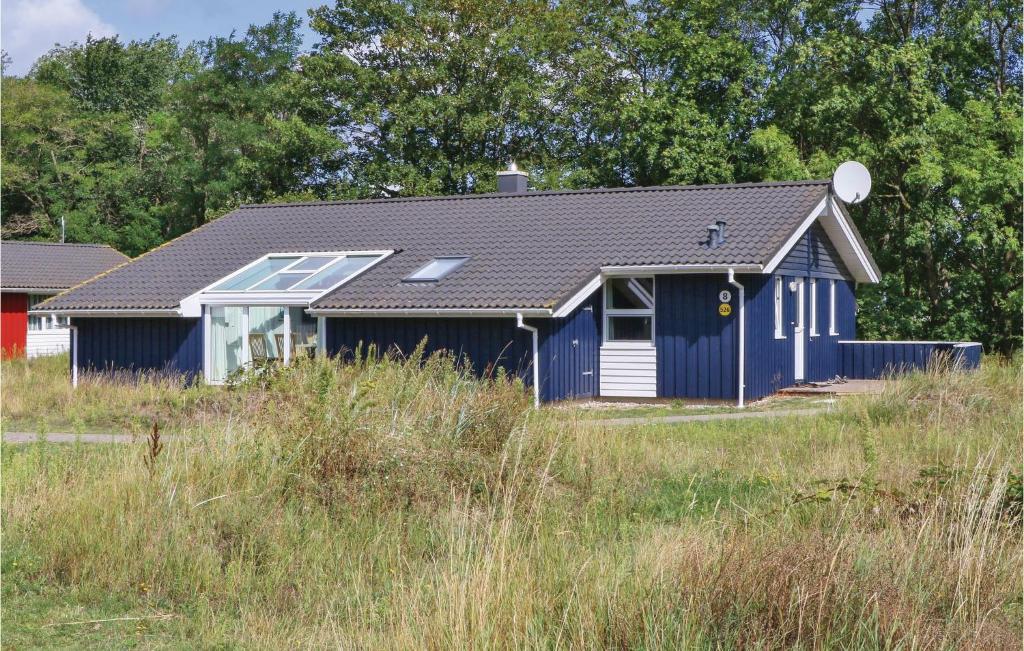 ein blaues und weißes Haus auf einem Grasfeld in der Unterkunft Freibeuterweg 8 - Dorf 6 in Travemünde