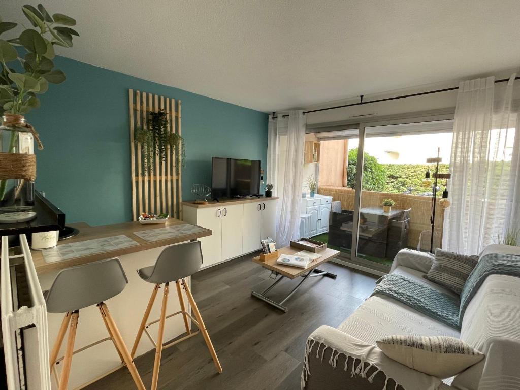 a living room with a couch and a table at Chaleureux appartement face au Port Sta Lucia, tout à pieds, wifi in Saint-Raphaël