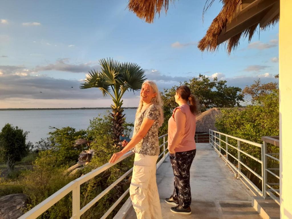two women standing on a walkway looking at the ocean at Oruwa Boutique Villas in Arugam Bay
