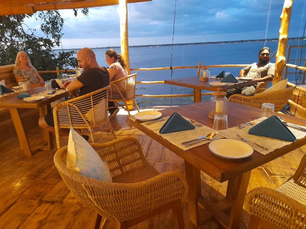 a group of people sitting at tables on a boat at Oruwa Boutique Villas in Arugam Bay