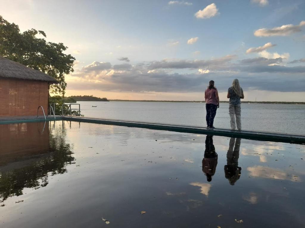 two people standing next to a pool of water at Oruwa Boutique Villas in Arugam Bay