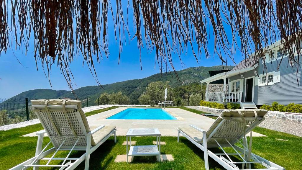 a house with two chairs and a swimming pool at The Box House & Charming Private Tiny House & Pool in Göcek