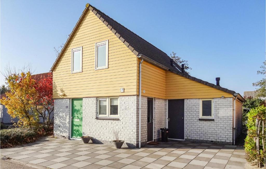 una casa con techo amarillo y entrada en Oesterbaai - 8 Personen, en Wemeldinge