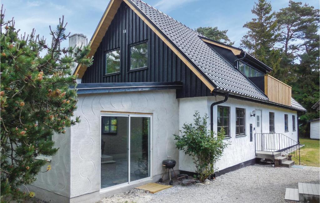 une maison avec un toit noir et une façade blanche dans l'établissement 3 Bedroom Pet Friendly Home In Borrby, à Borrby