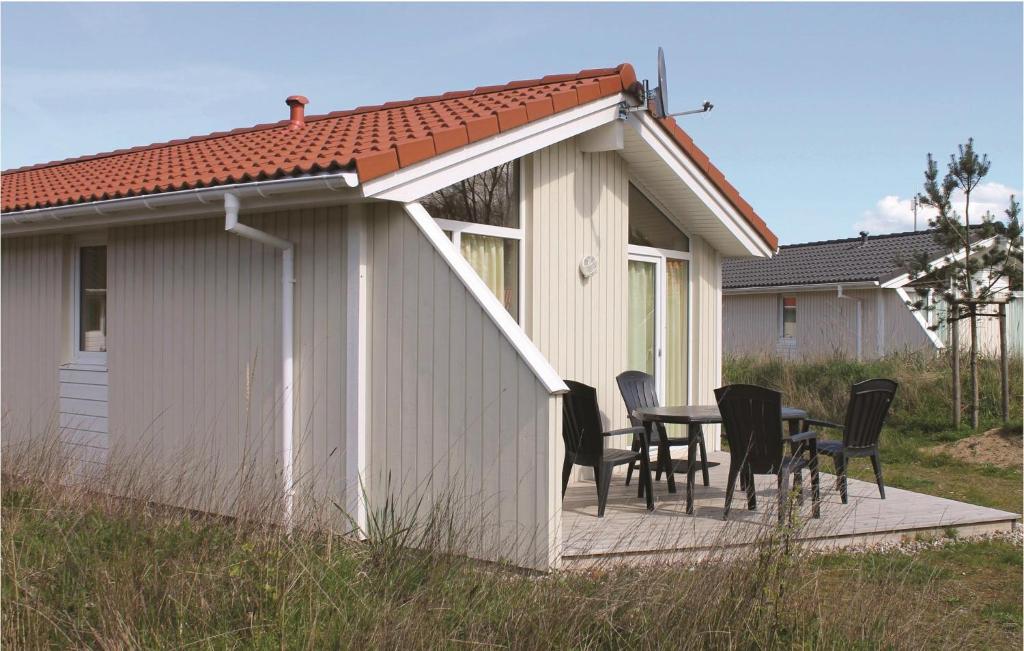 ein Haus mit einer Terrasse mit Stühlen und einem Tisch in der Unterkunft Schatzkiste 24 - Dorf 4 in Travemünde