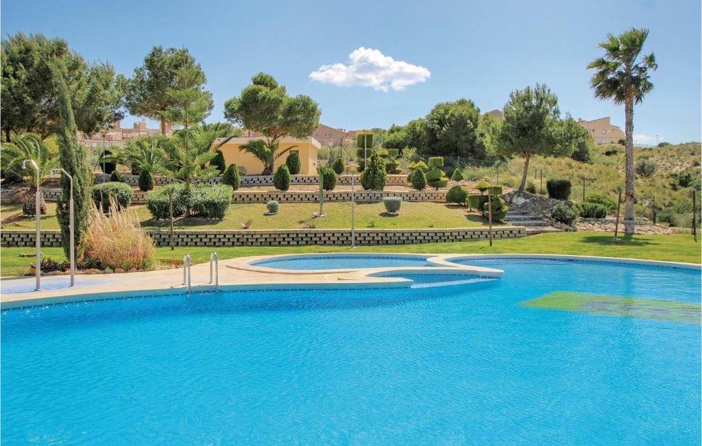 una piscina frente a una villa con árboles en Nice Apartment In Santa Pola With Kitchenette, en Santa Pola